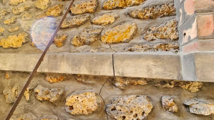 Fissure verticale grave mur en pierre tassement différentiel